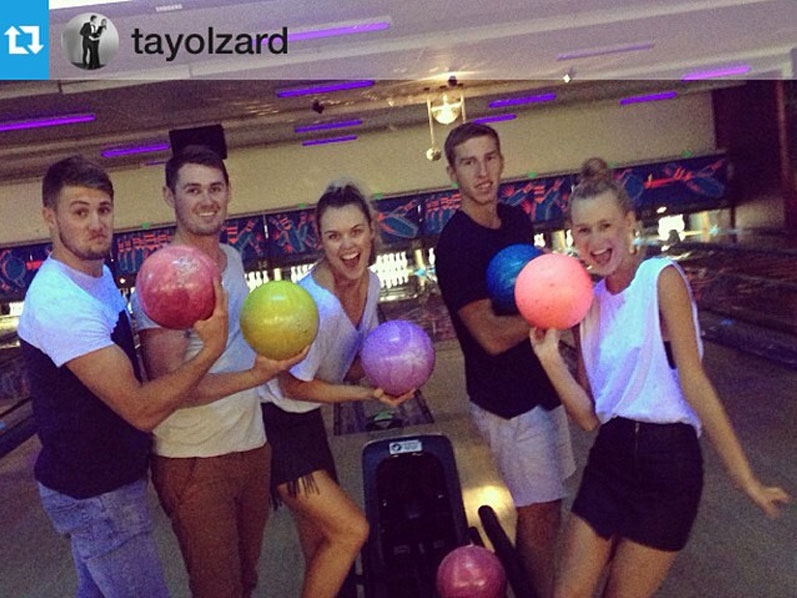 Group of girls and boys posing with bowling balls