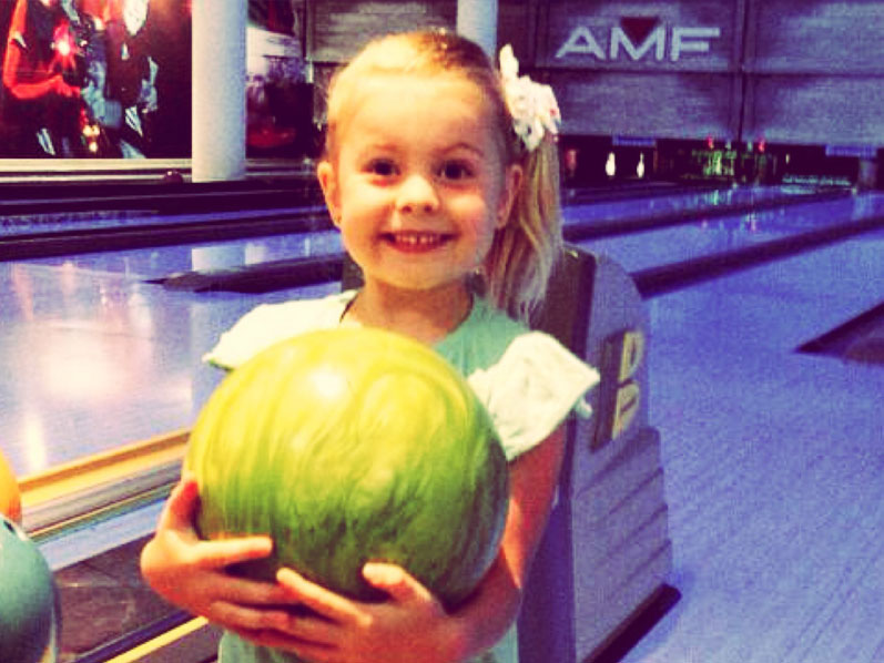 Young girl holding a bowling ball