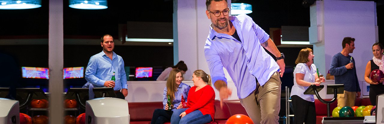 Guy bowls at ten pin bowling