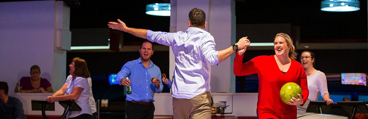 Adults high five at the bowling alley