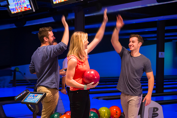 Friends high five at the bowling alley